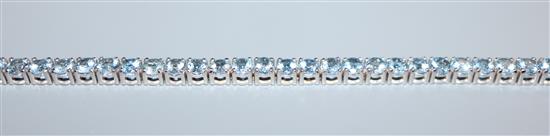 A 750 white metal and aquamarine set line bracelet, 18.2cm.